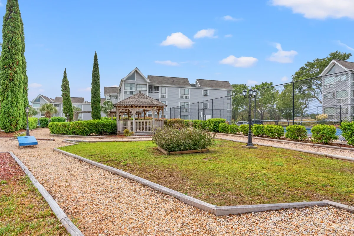 An inviting exterior area featuring a well-maintained tennis court, a charming gazebo with sunset views, and lush landscaped gardens where residents can picnic or unwind.